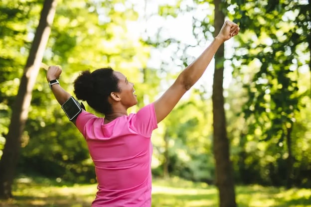 woman-celebrating-with-arms-raised-after-workout-outdoors